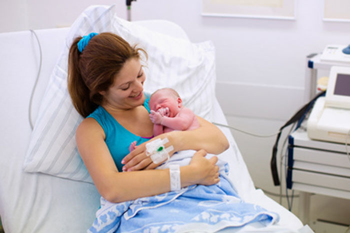 Mother holding her baby in labor and delivery room